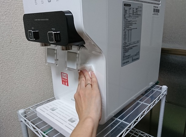 ウォータースタンドの外装を拭く手